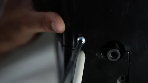 Hand tightening screw on black device with cables, Close-up of a hand using.. Stock Footage 338319449