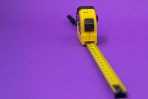 Hand tool Roulette construction yellow on purple background Stock Photos