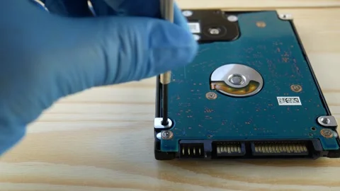 The hand with the tool tightens the bolt in the hard drive. Stock Footage 297943681