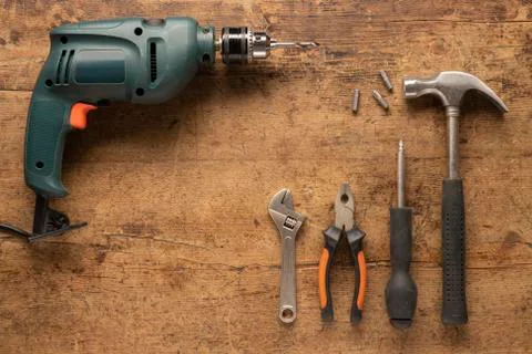 Hand tools and a drill on a dark wood background Foto stock