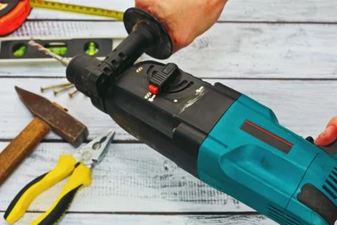 Hand tools and drilling machine in hands Stock Photos
