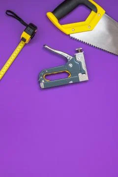 Hand tools yellow ruller, stapler, tape measure hand saw vertical Stock Photos
