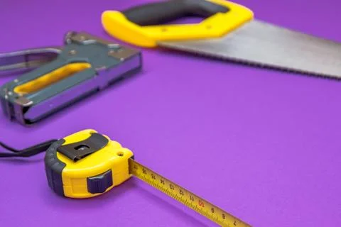 Hand tools yellow ruller, stapler, tape measure hand saw Stock Photos
