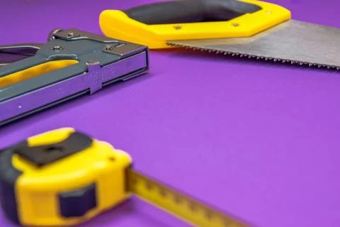 Hand tools yellow ruller, stapler, tape measure hand saw Stock Photos
