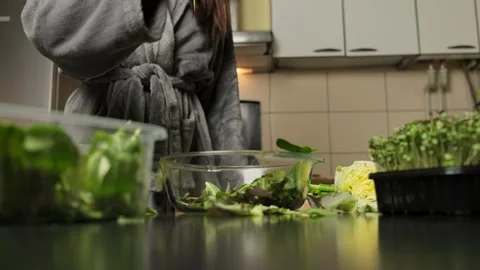Hand tossing arugula and spinach salad leaves Stock Footage 300096165