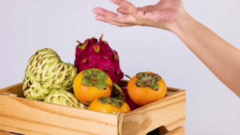 Hand Tossing Persimmon in Fruit Crate Vídeos de archivo 310530585