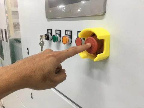 Hand touch on Emergency button machine in factory industrial Stock Photos