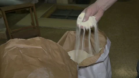 Hand touch a whole grain wheat flour in a sack, pouring a flour from the hand Stock Footage 173499840