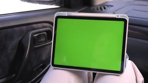 Hand touches green screen tablet while seated in vehicle interior Stock-Footage 341070042