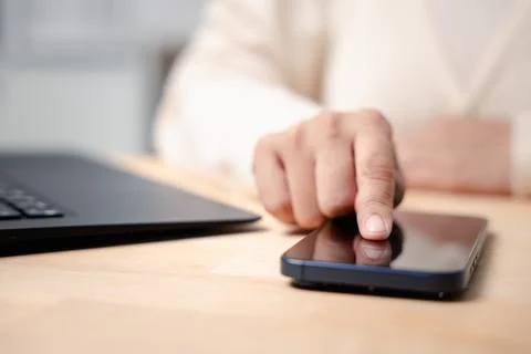 Hand touches smartphone screen using mobile phone technology online while w.. Stock Photos