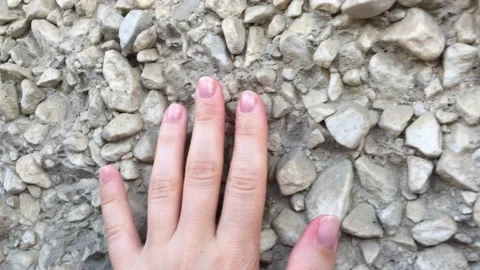 A hand touches stone wall Stock Footage 156331644