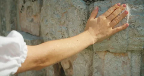 Hand touching ancient carved stone wall of Mayan ruins during tour in Mexico Stock Footage 311963833