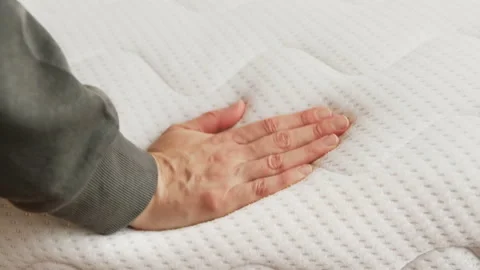 Hand touching and pressing orthopedic mattress on bed. Stock Footage 161890448
