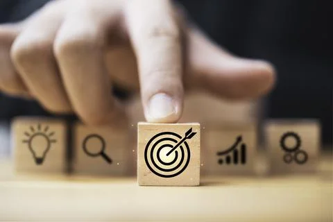 Hand touching and push target board which printing on wooden cube block on .. Stock Photos