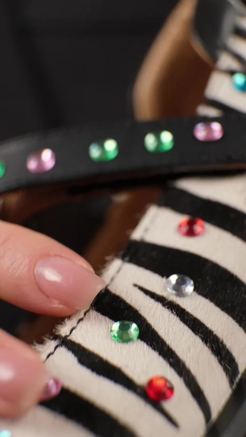 Hand Touching Beaded Strap on Zebra Shoe Stock Footage 303773775