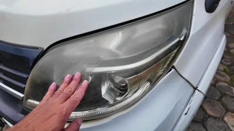 Hand touching cloudy and yellowed car headlight Stock Footage 331969151