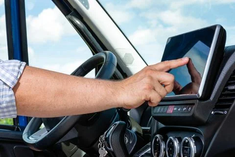 Hand touching digital screen on vehicle dashboard 写真素材