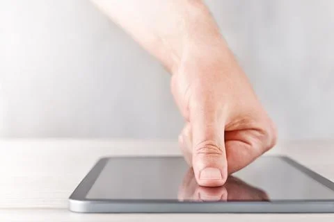 Hand touching digital tablet screen on light table with soft background, mode Stock Photos