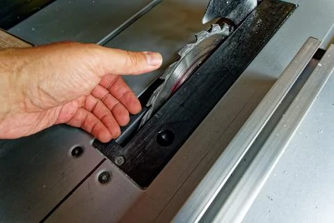 Hand touching electrical table saw blade Stock Photos
