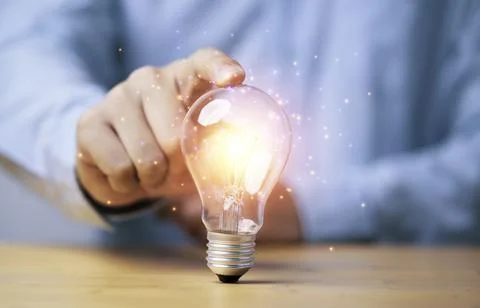 Hand touching to glowing lamp or lightbulb for creative thinking idea and p.. Stock Photos