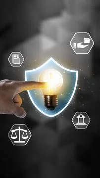 Hand touching a glowing lightbulb inside a shield, surrounded by legal icon.. Stock Photos