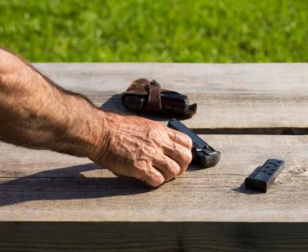 Hand touching a gun Stock Photos