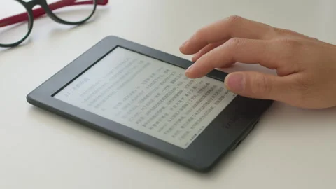 Hand Touching Kindle E-Reader Screen Displaying Text, Close-up Shot 库存影片 335502644