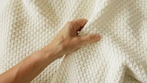 Hand touching knitted wool cloth or warm sweater. Handcraft knitting Stock Footage 247560287
