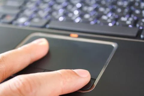 A hand is touching the laptop touchpad Stock Photos