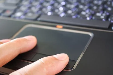 A hand is touching the laptop touchpad Stock Photos