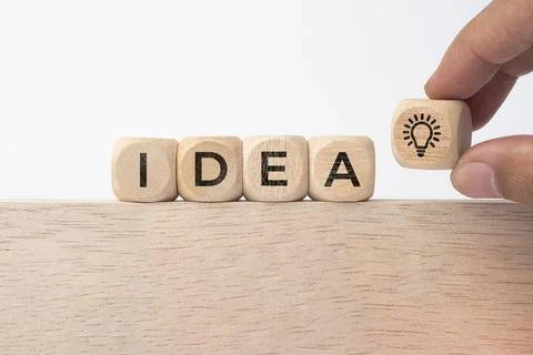 Hand touching on light bulb on wood block with Word Ideas, new idea concept.. 스톡 사진