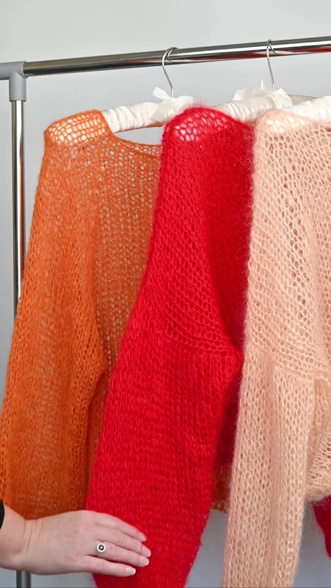 Hand touching orange red peach mohair sweaters. Stock Footage 334747796