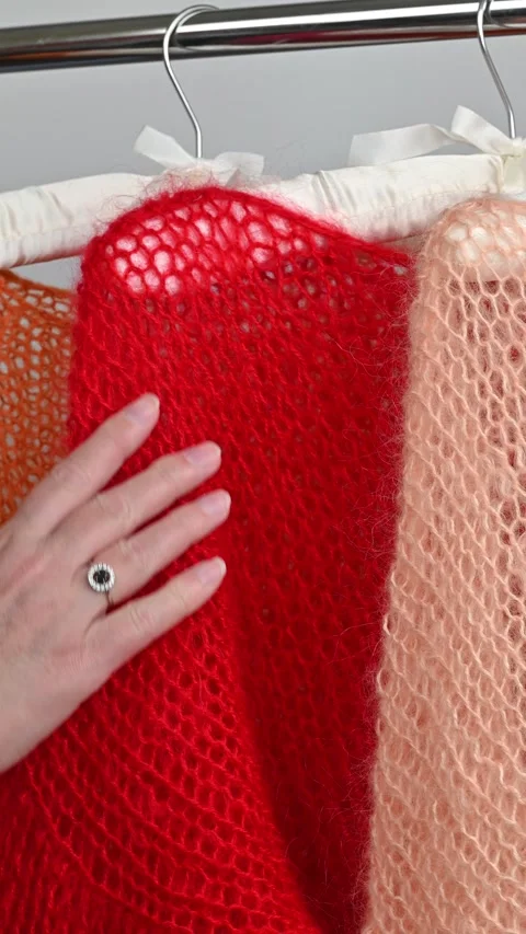 Hand touching red mohair scarf, soft fuzzy wool fabric, bright orange knit .. Stock Footage 334747780