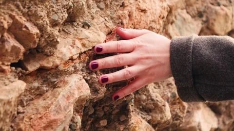 Hand touching rough sandstone texture close up footage. Natural stone surface. Stock Footage 329997119