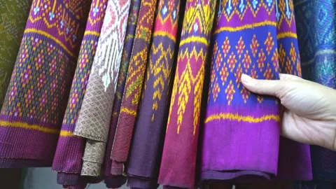 Hand touching rows of colorful traditional Thai silk fabrics, close up  Stock Footage 337073891