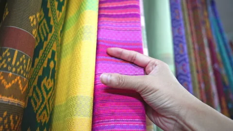 Hand touching rows of colorful traditional Thai silk fabrics, close up  Stock Footage 337073923