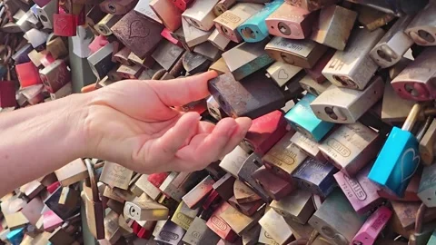 Hand touching a rusty love lock on a bridge railing Stock Footage 345096958