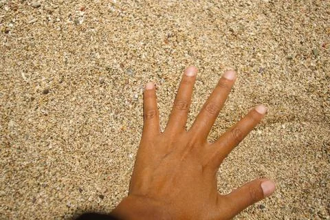 Hand touching sandy beach 写真素材