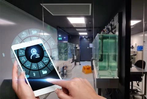 Hand Touching Screen Of Mobile Phone In Laboratory Showing Futuristic Techn.. Stock Photos