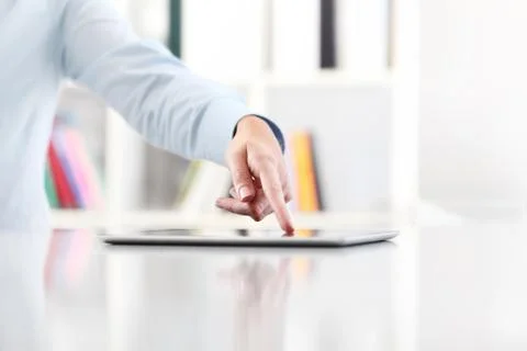 Hand touching screen tablet on desktop Stock-Fotos