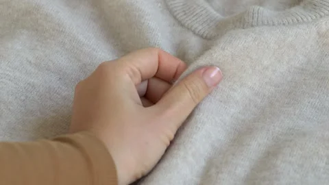 Hand touching soft woolen textile emphasizing comfort and tactile quality Video stock 332875942