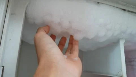 Hand touching thick layer of accumulated white frost Stockbeeldmateriaal 333443251