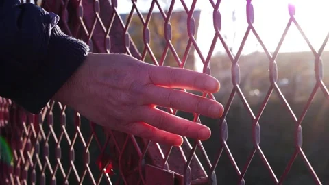Hand touching urban area through wire fence 스톡 동영상 167234726