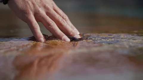 Hand touching water slowmotion Stock Footage 128391580