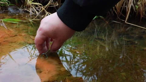 Hand touching water surface while exploring nature in tranquil setting Vídeo Stock 295338148