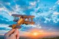 The hand with a toy airplane on the background of a sunset Photo