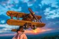 The hand with a toy plane against the background of a sunset Photo