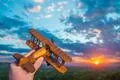 The hand with a toy plane against the background of a sunset Photo