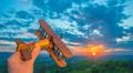 The hand with a toy plane against the background of a sunrise Photo