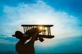 The hand with a toy plane on the background of the sunrise Photo